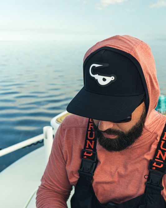 Fisherman on a boat wearing the jigalode black performance snapback.