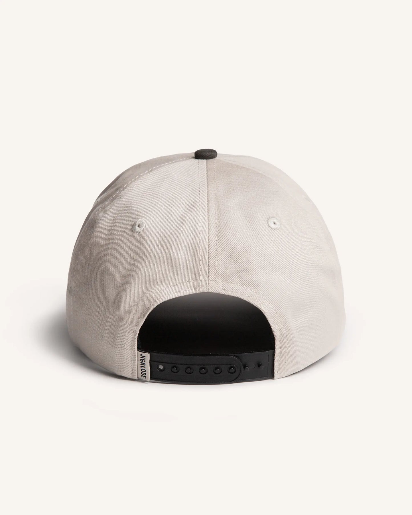 Back shot of the Tailer Snapback. It is a tone toned hat (Natural crown with a dark gray brim) retro styled snapback with a school of bonefish tails embroidered in the front.