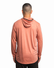Back view of male model wearing the Jigalode Mighty Jig Performance Fishing Hoodie in rust orange with an all-over tropical plant pattern. The hoodie, with the hood off, features a super soft fabric and offers UPF 30 sun protection. The model highlights the hoodie's design and comfort.