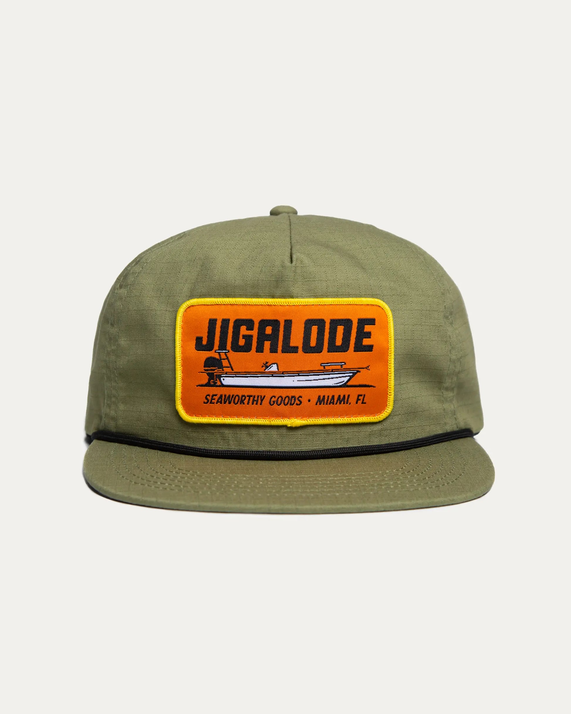 Front of the Seaworthy fishing Snapback. It is green with an orange patch with a yellow border. The patch features a poling skiff that says "Seaworthy Goods"
