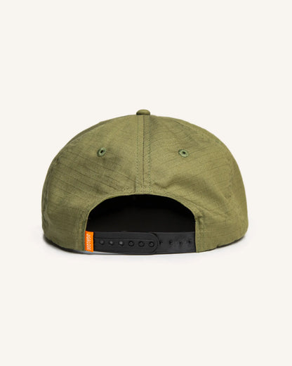 Back of the Seaworthy fishing Snapback. It is green with an orange patch with a yellow border. The patch features a poling skiff that says "Seaworthy Goods"